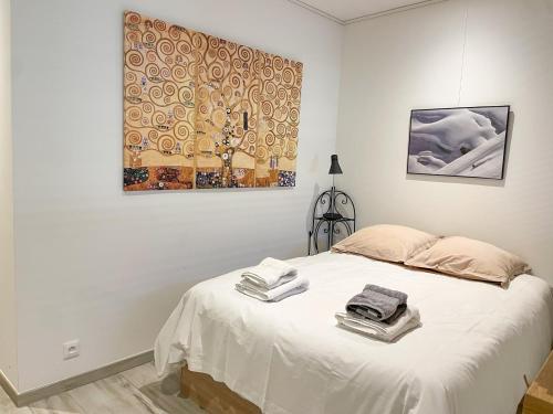 タロワールにあるLe Loft à deux pas du Lacの白いベッドルーム(タオル付きのベッド付)