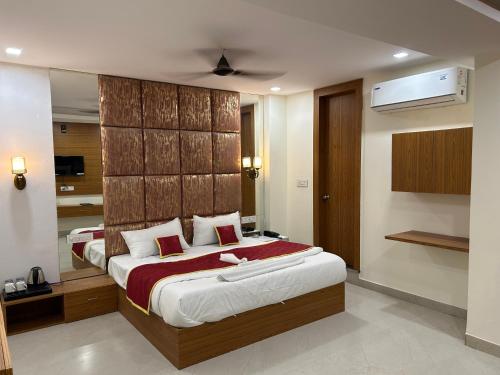um quarto com uma cama grande e um espelho em Hotel Cosmopolitan Rooms & Banquet em Allahabad