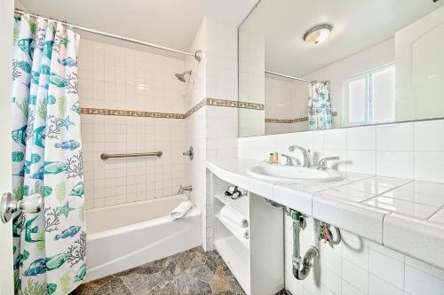 a bathroom with a sink and a tub and a shower at Seascape Compound in Newport Beach