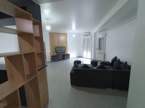 貝賈亞的住宿－Bienvenus à Bejaia F3 6p，客厅配有黑色沙发和电视