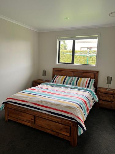a bedroom with a large bed with a window at MataMata in Matamata