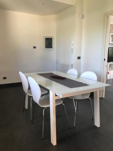 einen weißen Esstisch mit weißen Stühlen in der Unterkunft Case Vesta in Villasmundo