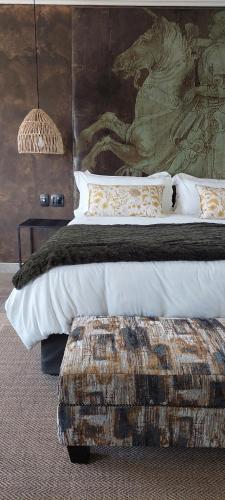 a bedroom with a large bed with a large painting at Bannockburn Guest Cottage in White River