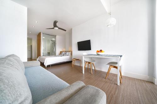 ein Wohnzimmer mit einem Sofa und einem Tisch in der Unterkunft Estudio con terraza vista mar in Las Palmas de Gran Canaria