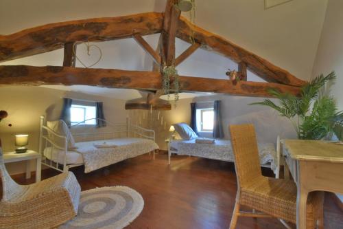ein Wohnzimmer mit 2 Betten, einem Tisch und Stühlen in der Unterkunft Chambre d'hôtes L'altitude - Domaine la Rose des vents in Castelnau-sur-lʼAuvignon