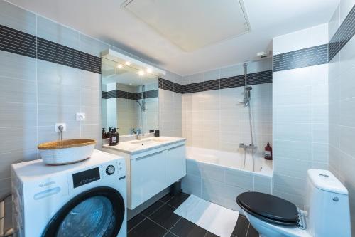 a washing machine in a bathroom with a sink and a toilet at Prado Beach - Appt avec terrasse in Marseille