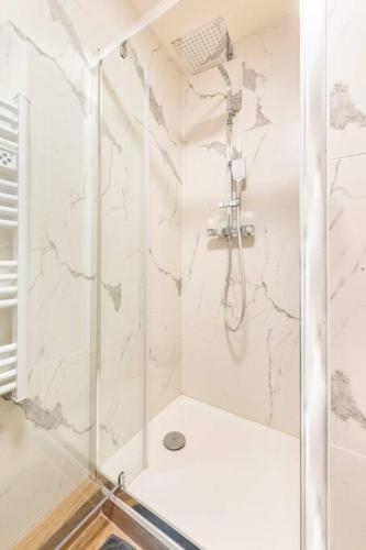 une douche avec une porte vitrée dans une salle de bain dans l'établissement Le Forbin : Studio standing Centre Aix avec Clim, à Aix-en-Provence