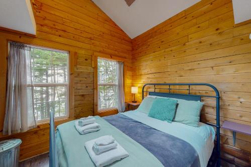 a bedroom with a bed in a log cabin at The Lazy Lumberjack Cottages in Franklin