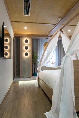 a bedroom with a bed with a white canopy at Jacayl Hotel - Cầu Giấy in Hanoi