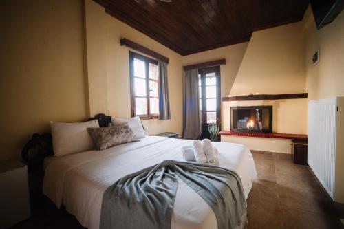 a bedroom with a large bed with two towels on it at Pliades Traditional Guesthouse in Palaios Panteleimon