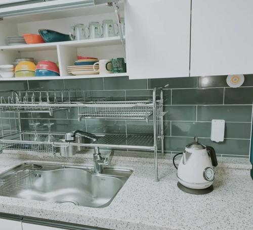 a kitchen counter with a sink and a tea kettle at Cooing in Chuncheon