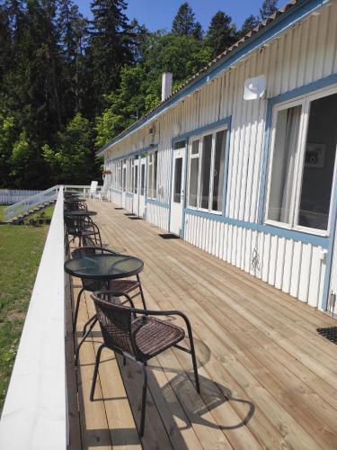 a deck with chairs and tables and a building at Lainela puhkeküla in Käsmu