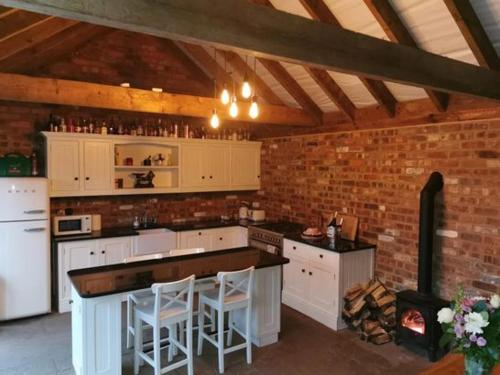 a kitchen with white cabinets and a brick wall at Moon Valley Glamping 
