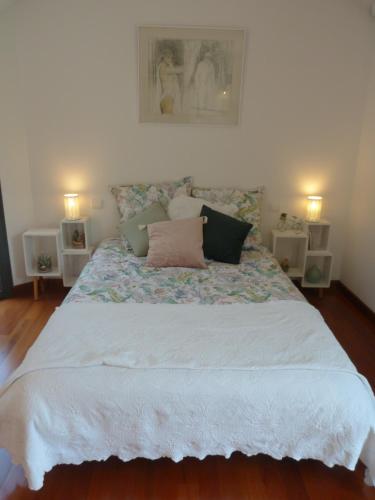 Un dormitorio con una cama grande con almohadas. en La Désirade, en Salles-la-Source