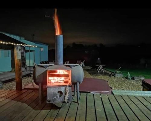 a wood fired stove on a deck at night at Moon Valley Glamping 