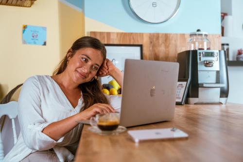 a woman sitting at a table with a laptop computer at Jabitat- Jaffa Boutique TLV in Tel Aviv