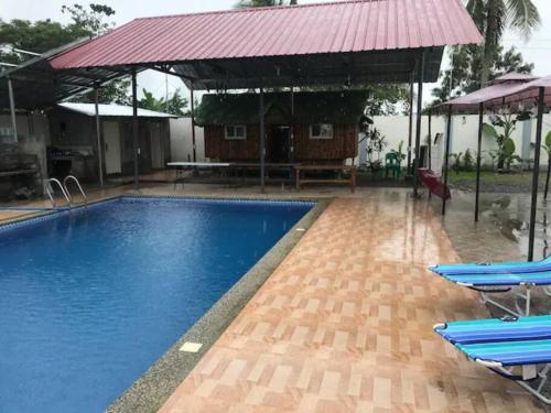 una piscina con sillas azules y techo rojo en Rainiers Private Resort house has 2 rooms 2 huts total of 5 rooms, 