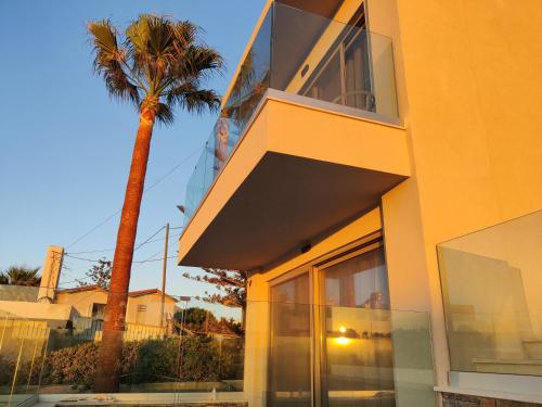 a yellow building with a palm tree in front of it at Niriides Palace in Gournes
