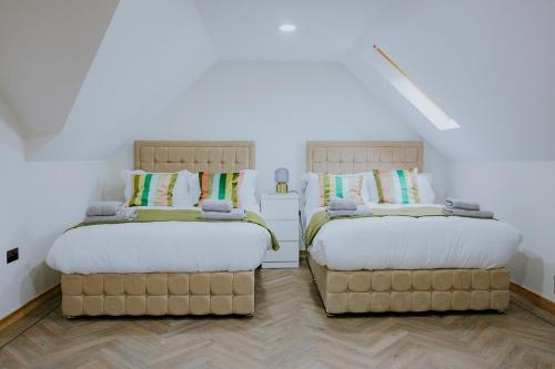 two beds sitting next to each other in a room at New fully furnished 5 bedroom, 4 bathroom detached houses in Leicester