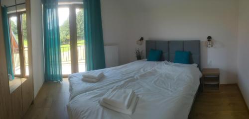 a white bed with blue pillows in a bedroom at Kraina Rysia in Berezka
