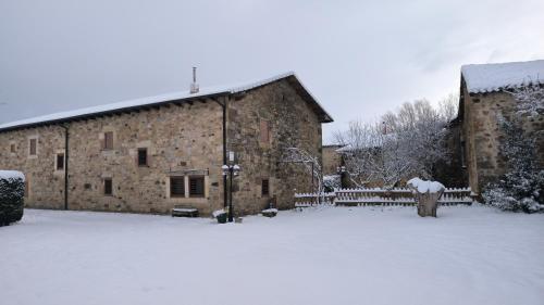 a large stone building with snow on the ground at La Galana in Nestar