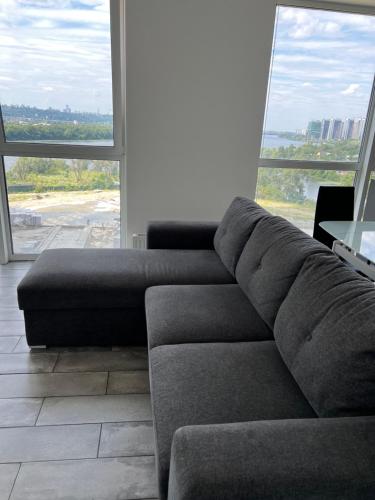 un divano in soggiorno con una grande finestra di 4 rooms apartment with a view to the Dnieper River a Kiev