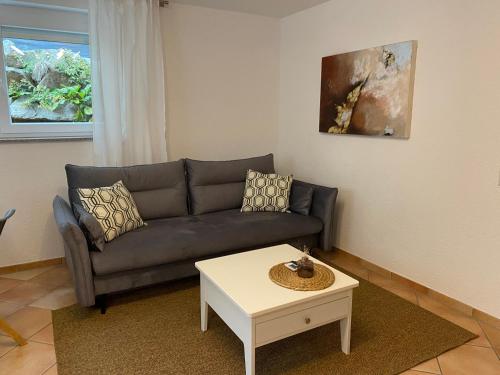 a living room with a couch and a table at Ferienwohnung im Sand in Herbolzheim