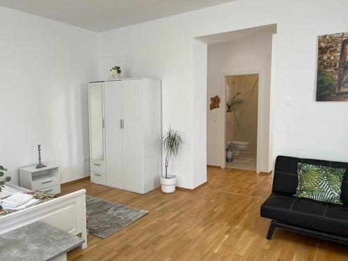 ウィーンにあるvienna city apartment 1のリビングルーム(黒いソファ、白いキャビネット付)