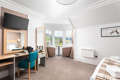 um quarto de hotel com uma secretária e uma cama em Caledonian Hotel 'A Bespoke Hotel’ em Ullapool