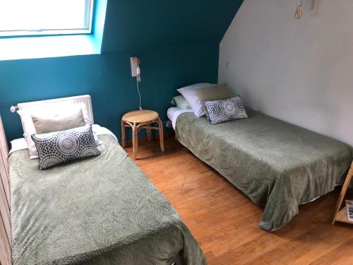 a room with two beds and a chair in it at Grande Chambre Familiale VERTE Tout Bonnement Bien in Putot-en-Auge