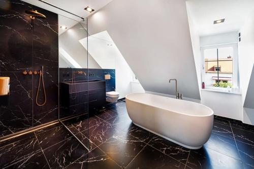 bagno con vasca e doccia in vetro di Highlight Penthouse mit rund 160 m2 a Monaco