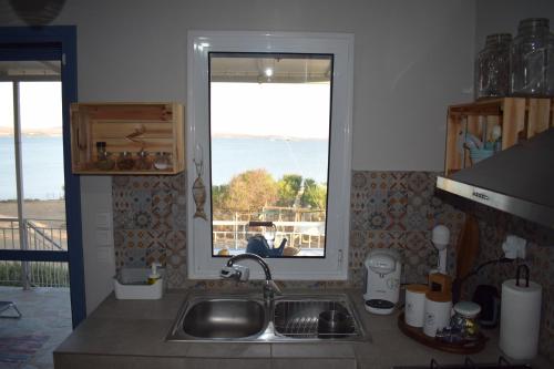 cocina con fregadero y ventana en Seaside resort- kallithea, 