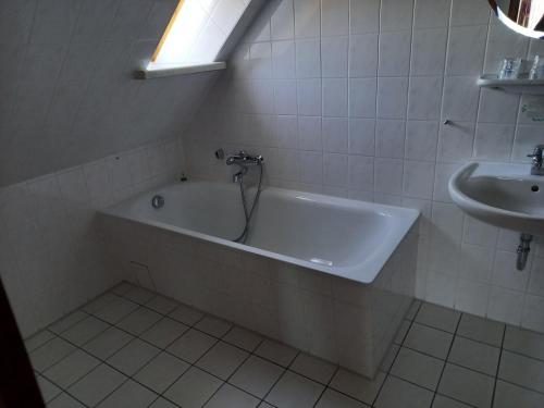 ein Badezimmer mit einer Badewanne und einem Waschbecken in der Unterkunft Gasthaus Zum Rethberg in Lübstorf