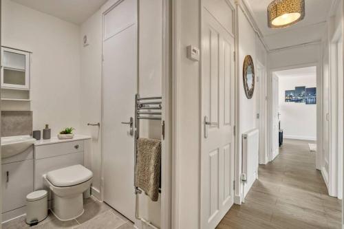 La salle de bains blanche est pourvue de toilettes et d'un lavabo. dans l'établissement Hidden Gem in Battersea w/ Free Parking, à Londres