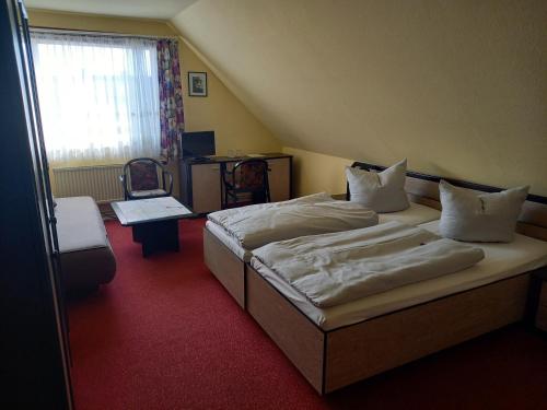 a hotel room with two beds and a window at Gasthaus Zum Rethberg in Lübstorf