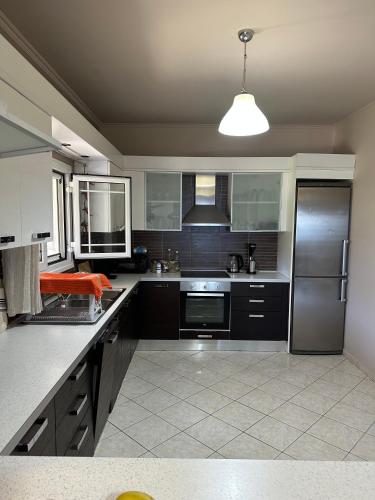 a large kitchen with black cabinets and a refrigerator at Villa Long View in Avliótai