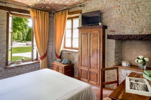 - une chambre avec un lit et une télévision murale dans l'établissement Relais Montemarino, à Borgomale