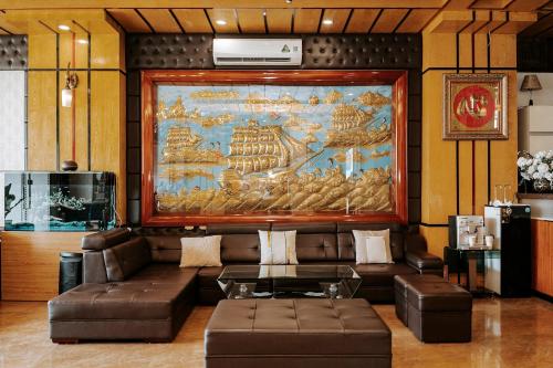 uma sala de estar com um sofá e uma grande pintura na parede em Thao Vy Hotel em Hai Phong