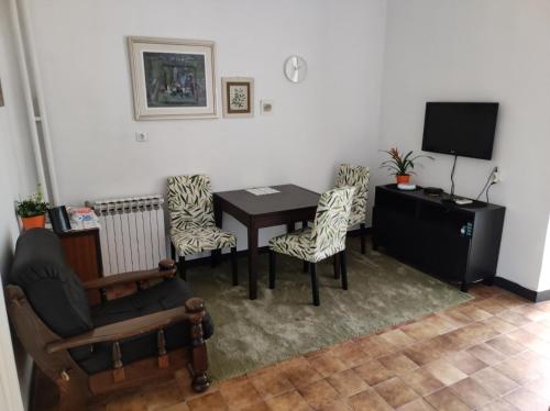 a room with a table and chairs and a television at ArenaApp in Pula