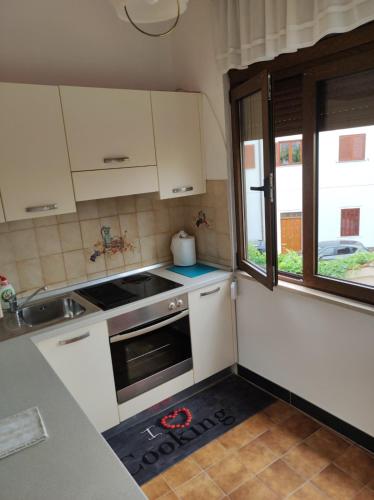 a kitchen with white cabinets and a sink and a window at ArenaApp in Pula