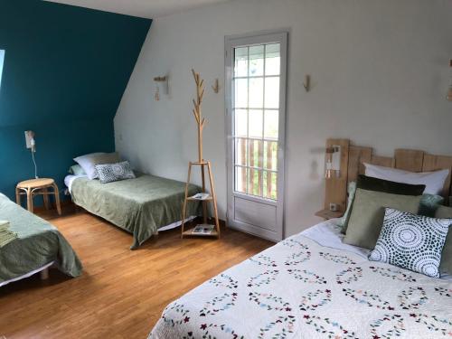 a bedroom with two beds and a window at Grande Chambre Familiale VERTE Tout Bonnement Bien in Putot-en-Auge