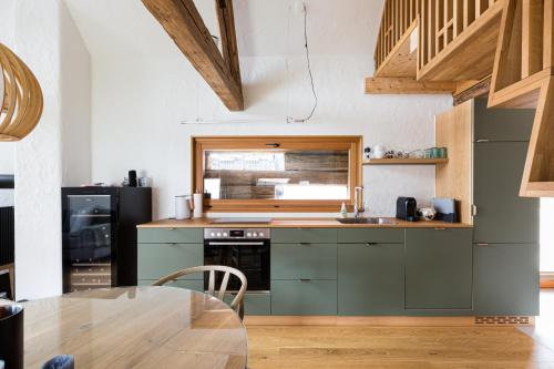uma cozinha com armários verdes e uma mesa de madeira em dieKELLERSTÖCKL - Das Rosenstöckl S22 mit Mini-Pool em Stainz