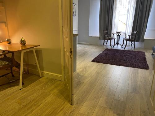 a living room with a table and chairs and a wooden floor at The Nash Suite - one minute walk to beach in Brighton & Hove