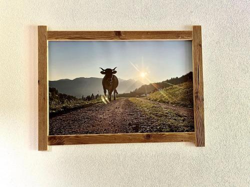 a picture of a cow walking down a dirt road at Bioberghof Rohr in Fieberbrunn
