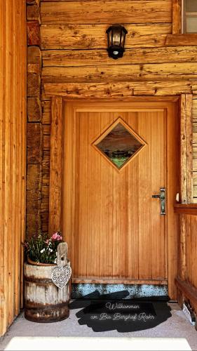 a wooden door with a planter in front of it at Bioberghof Rohr in Fieberbrunn
