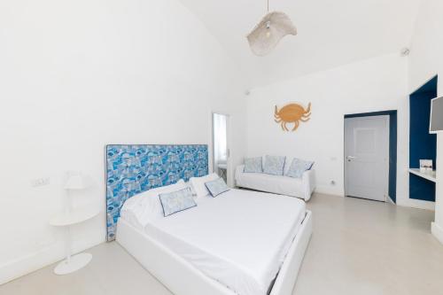 a white bedroom with a bed and a spider on the wall at Villa La Pergola Capri in Capri