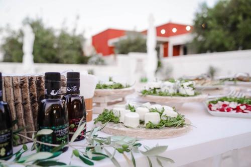 a table with bottles of alcohol and candles on it at Tenuta Amostuni-Country House in Ostuni