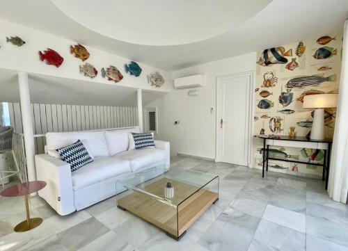 sala de estar con sofá blanco y mesa de cristal en GOLDEN MILE FRONT LINE BEACH RESORT en Marbella