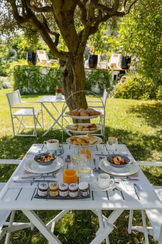 a white table with food on it under a tree at Villa La Pergola Capri in Capri
