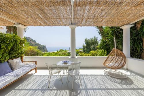 a patio with a couch and chairs and a table at Villa La Pergola Capri in Capri
